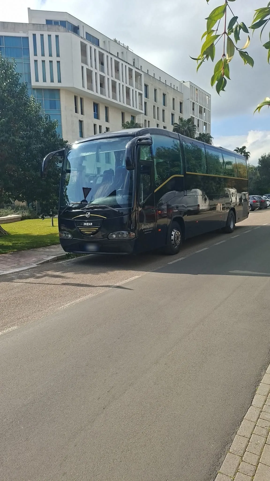 Midibus nero Irizar davanti a un hotel